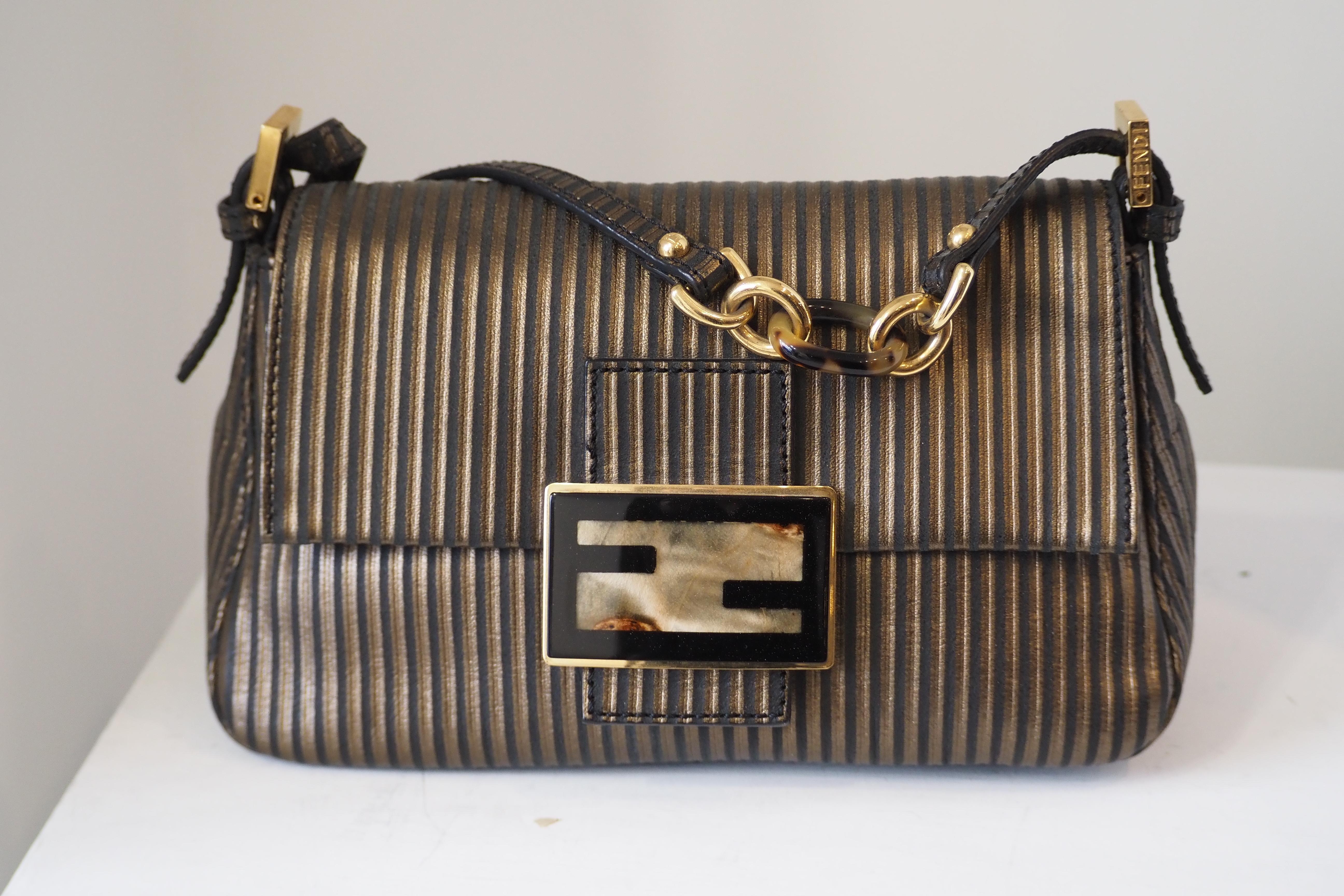 Fendi mamma baguette brown and gold handle bag
Collezione : Baguette
Modello : Mamma Baguette
Genere : Donna
Periodo : 2000
Colore : Marrone, Nero
Materiale : Tela e pelle
Lunghezza : 34 cm
Altezza : 26 cm
Larghezza : 14 cm
Categoria : Borsa