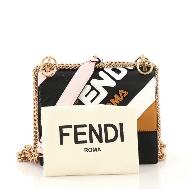 This Fendi Mania Kan I Bag Inlaid Leather Small, crafted from black and pink leather, features a chain link strap with leather pad, Fendi Mania inlays and FF pattern, and gold-tone hardware. Its twist-lock closure opens to a beige microfiber