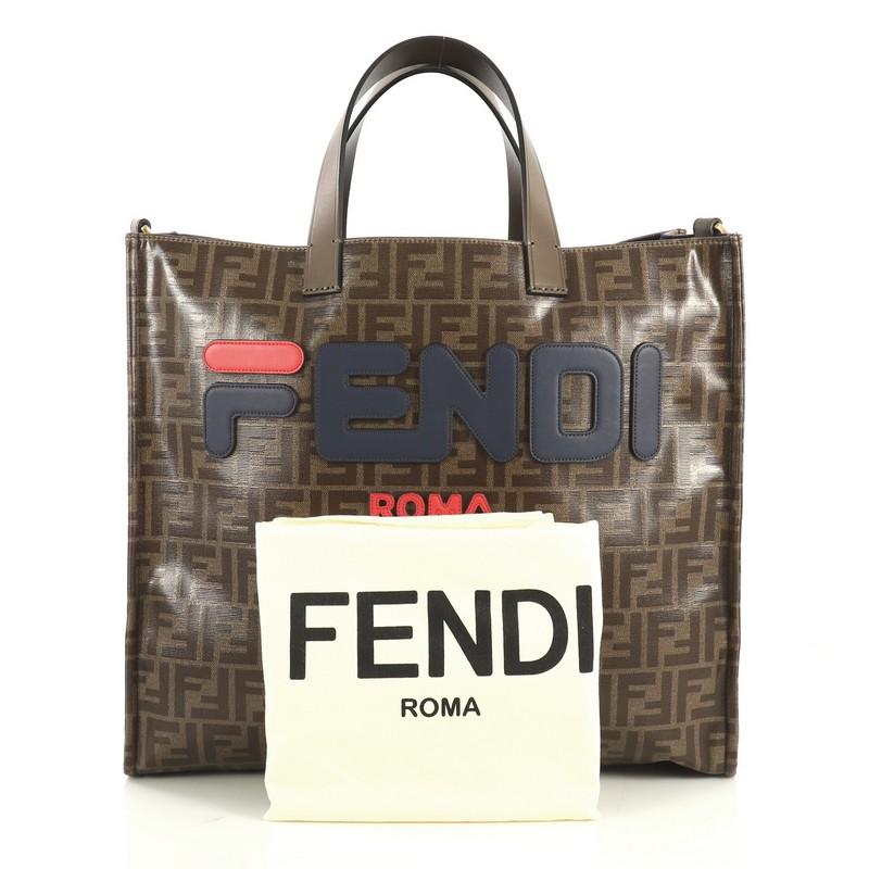 This Fendi Mania Logo Shopper Tote Zucca Coated Canvas Large, crafted from brown zucca coated canvas, features dual top handles and gold-tone hardware. It opens to a blue wool and felt interior with zip pocket. 

Estimated Retail Price: