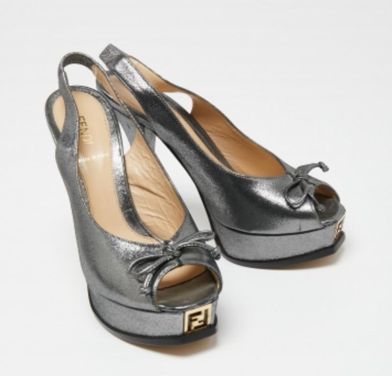 Estas sandalias Fendi te ofrecerán un look seguro y chic. Confeccionados en ante gris, su punta peep-toe está adornada con un bonito lazo y la firma de la marca en la parte delantera añade un toque de sofisticación a estos zapatos. El cierre