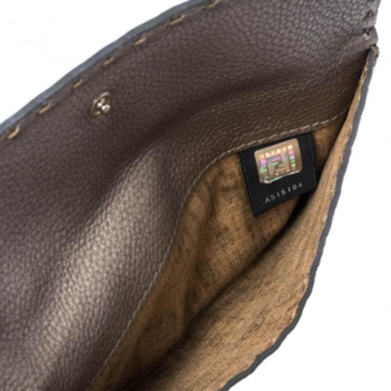 This luxe wallet from the house of Fendi is meticulously crafted from leather and designed with their signature Selleria stitch detailing. Styled with a flap, the metallic wallet is equipped with multiple slots and compartments to carry your