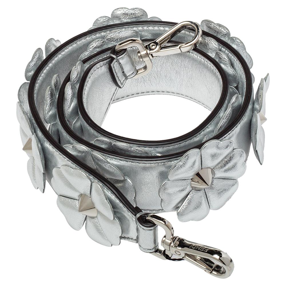 Fendi brings you this super-chic shoulder strap that you can flaunt with your great collection of handbags. The strap is made from metallic silver leather and designed with floral appliques. It is complete with two silver-tone clasps for you to