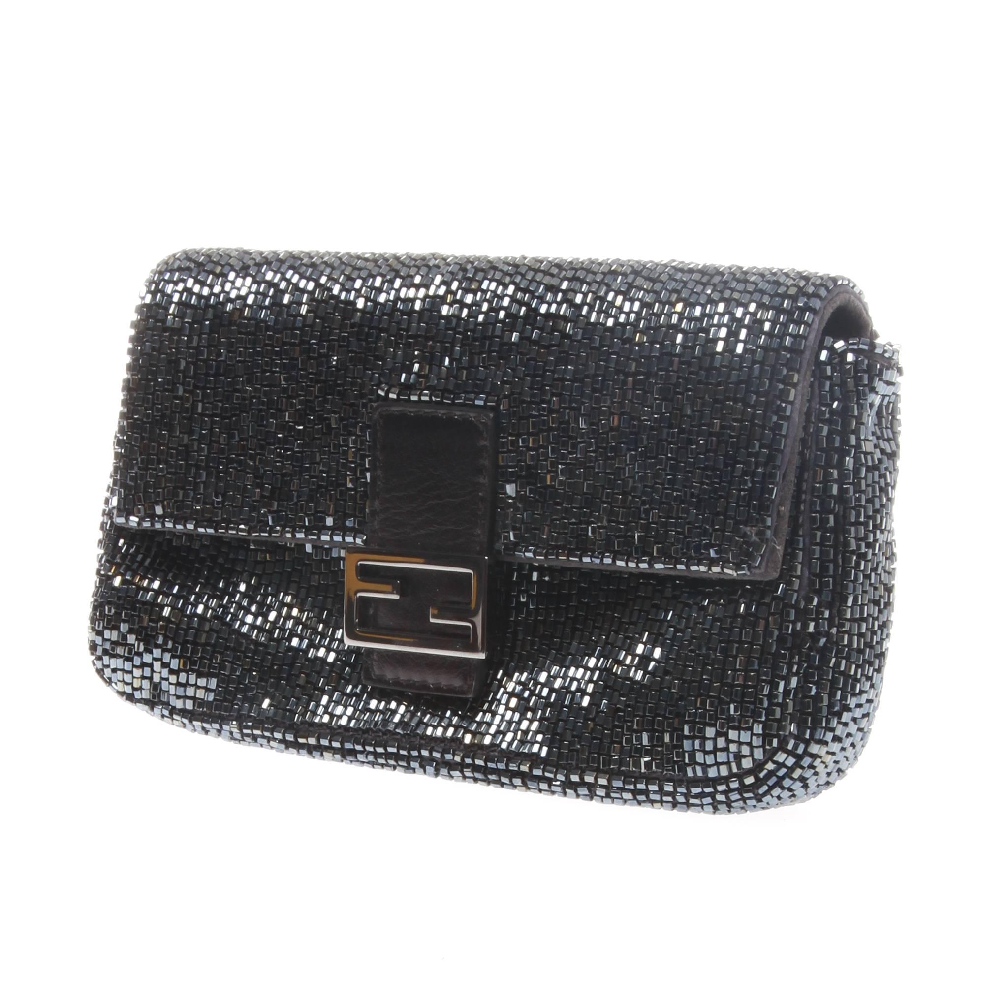 A black ruthenium glass and gun mental covered black goat skin micro 'Baguette' clutch from Fendi featuring a foldover top with magnetic closure, 
internal slip pocket, internal logo patch, chain strap and a gold-tone signature FF logo. 