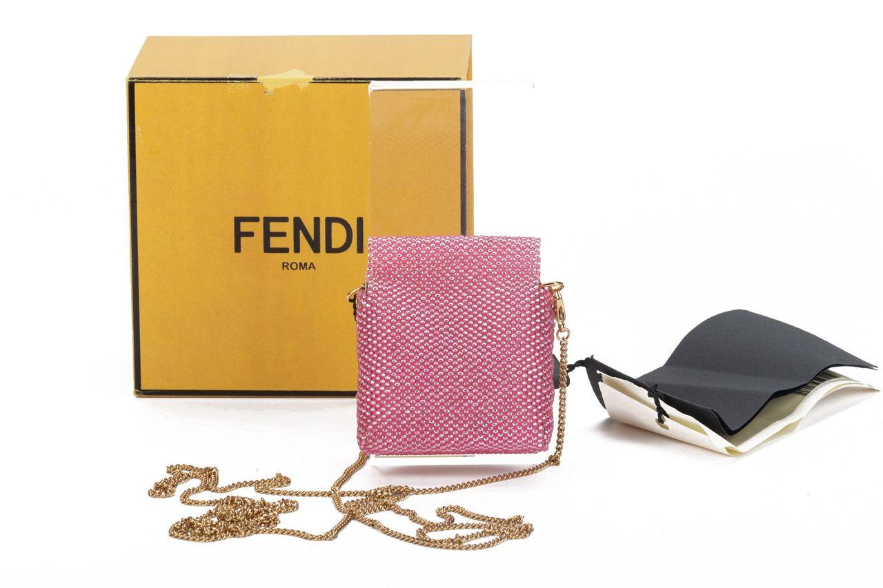 Fendi micro baguette in pink. It's weaved of little plastic balls. On front of it is gold clasp with the typical F logo. The bag can be worn over the shoulder with the detachable chain (23