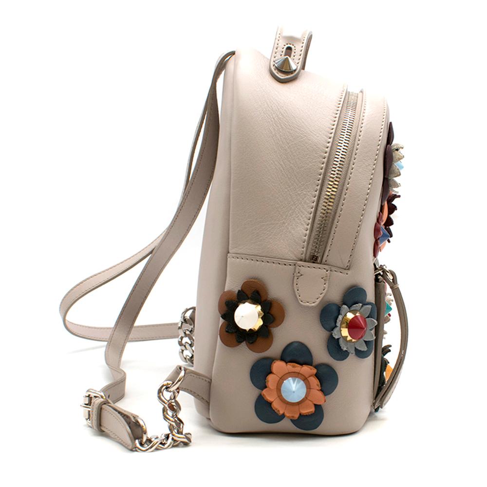 Fendi Mini Floral Appliqué Backpack

- Dust grey calfskin leather mini flower appliqué backpack.
- Featuring a front zip pocket
- Front centre logo stamp
- Top handle and two-way zip fastening
- Silver-tone hardware with internal pockets. 
- Thin