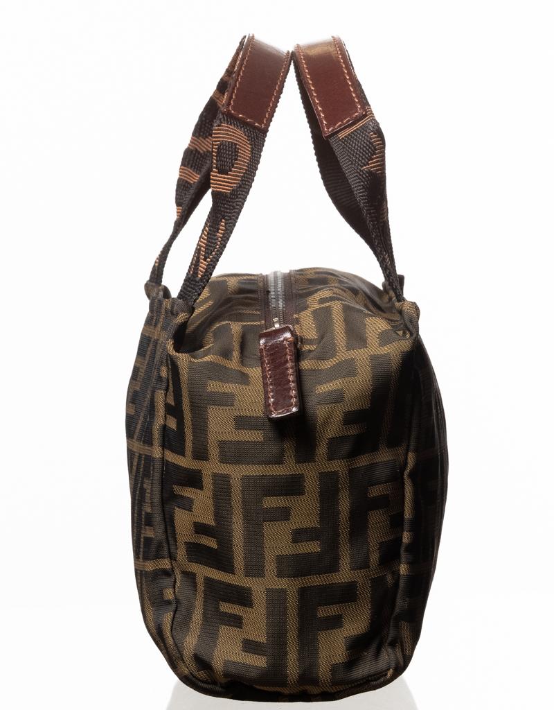 This vintage Fendi Boston bag is made with brown Zucca fabric with a with Fendi Roma Handle. Top zip closure with logo jacquard lining and leather finishes.

COLOR: Brown
MATERIAL: Canvas
MEASURES: H 6” x W 7” x D 2”
EST. RETAIL: $1200
CONDITION: