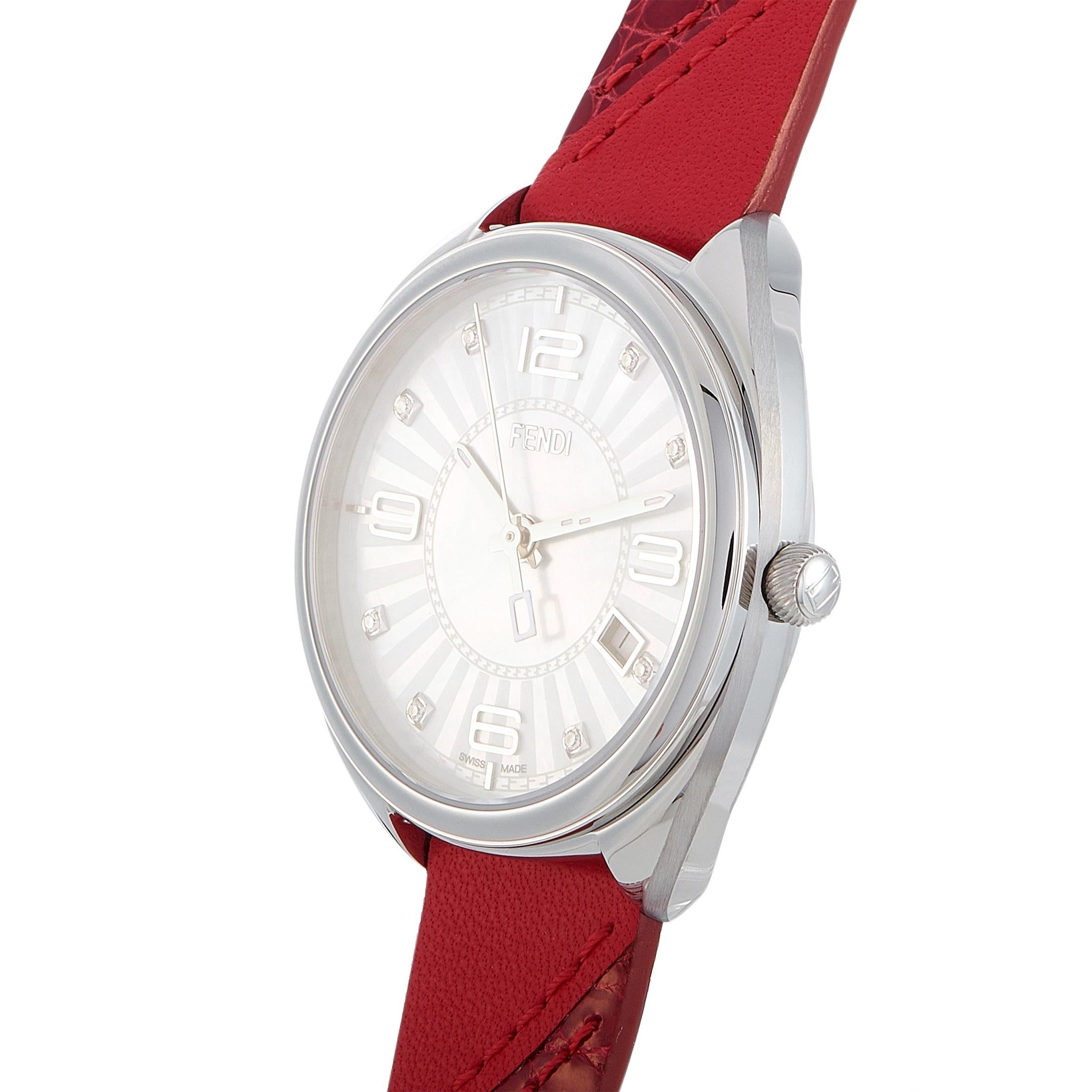 The Fendi Momento watch, reference number F217034573D1, boasts a 34 mm stainless steel case that is presented on a red leather strap, secured on the wrist with a tang buckle. This model is powered by a quartz movement and indicates hours, minutes,
