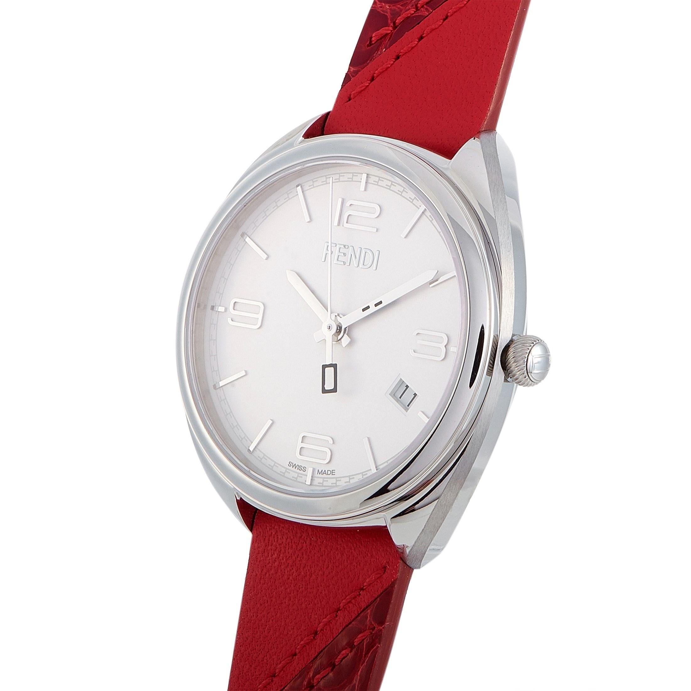 The Fendi Momento watch, reference number F210034073, boasts a 34 mm stainless steel case that is presented on a red leather strap, secured on the wrist with a tang buckle. This model is powered by a quartz movement and indicates hours, minutes,