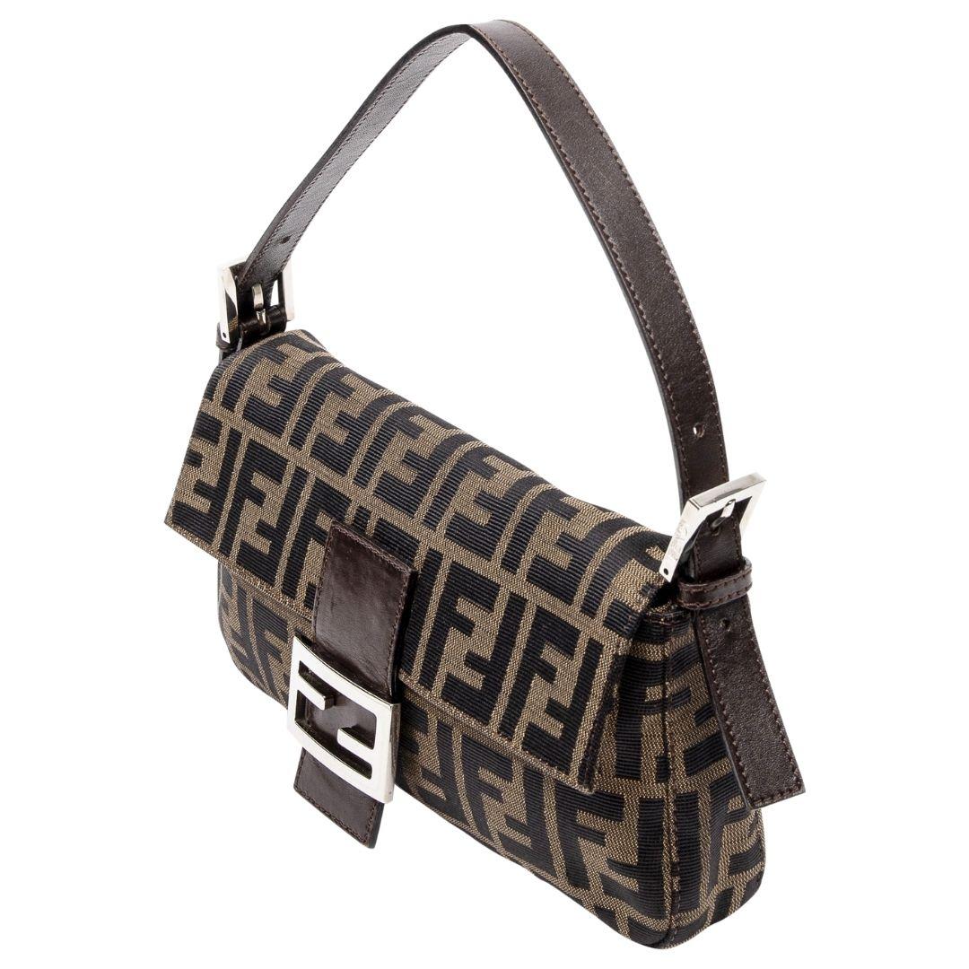 Fendi's Monogram Classic Baguette features timeless brown canvas with silver hardware, a magnetic snap closure, and a matching canvas interior that includes one zippered pocket for organization.

SPECIFICS
• Length: 10.25