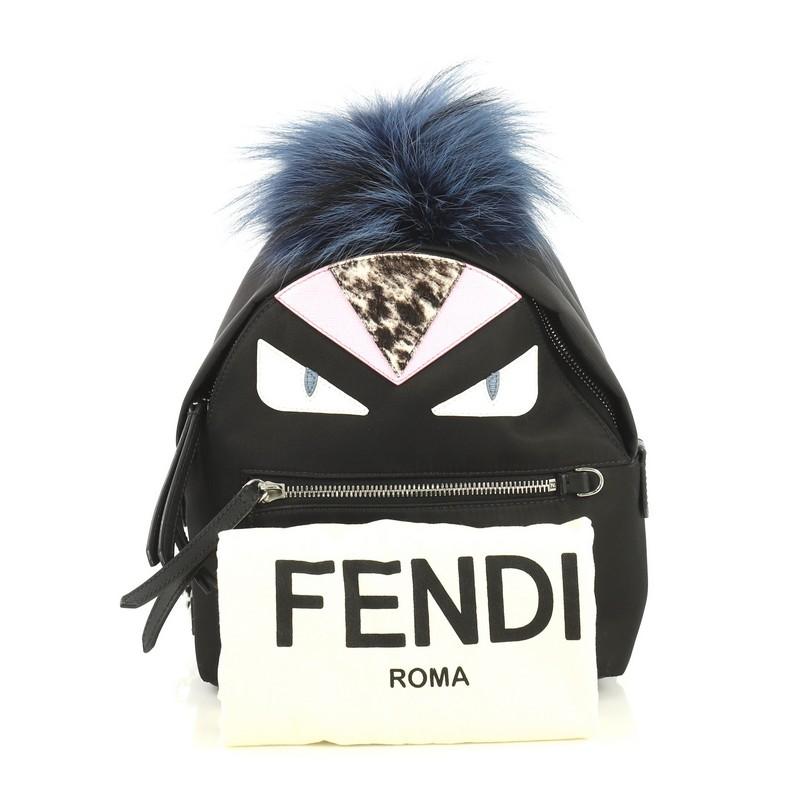 This Fendi Monster Backpack Nylon with Leather and Fur Mini, crafted from black nylon with leather and fur, features adjustable shoulder straps, monster design, exterior front zip pocket, and silver-tone hardware. Its zip closure opens to a black