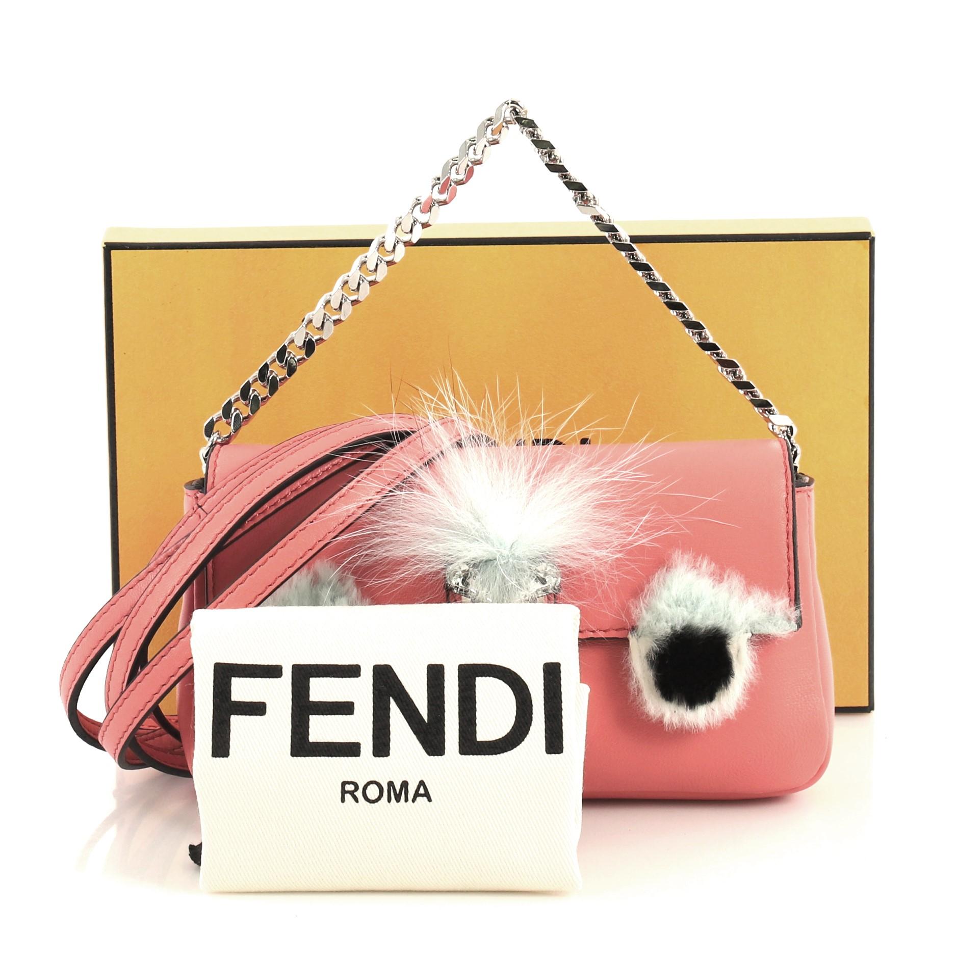 This Fendi Monster Baguette Leather and Fur Micro, crafted from pink leather and fur, features monster design in genuine fox and rabbit fur accents adorned with pearls and crystals, adjustable leather strap, and silver-tone hardware. Its magnetic