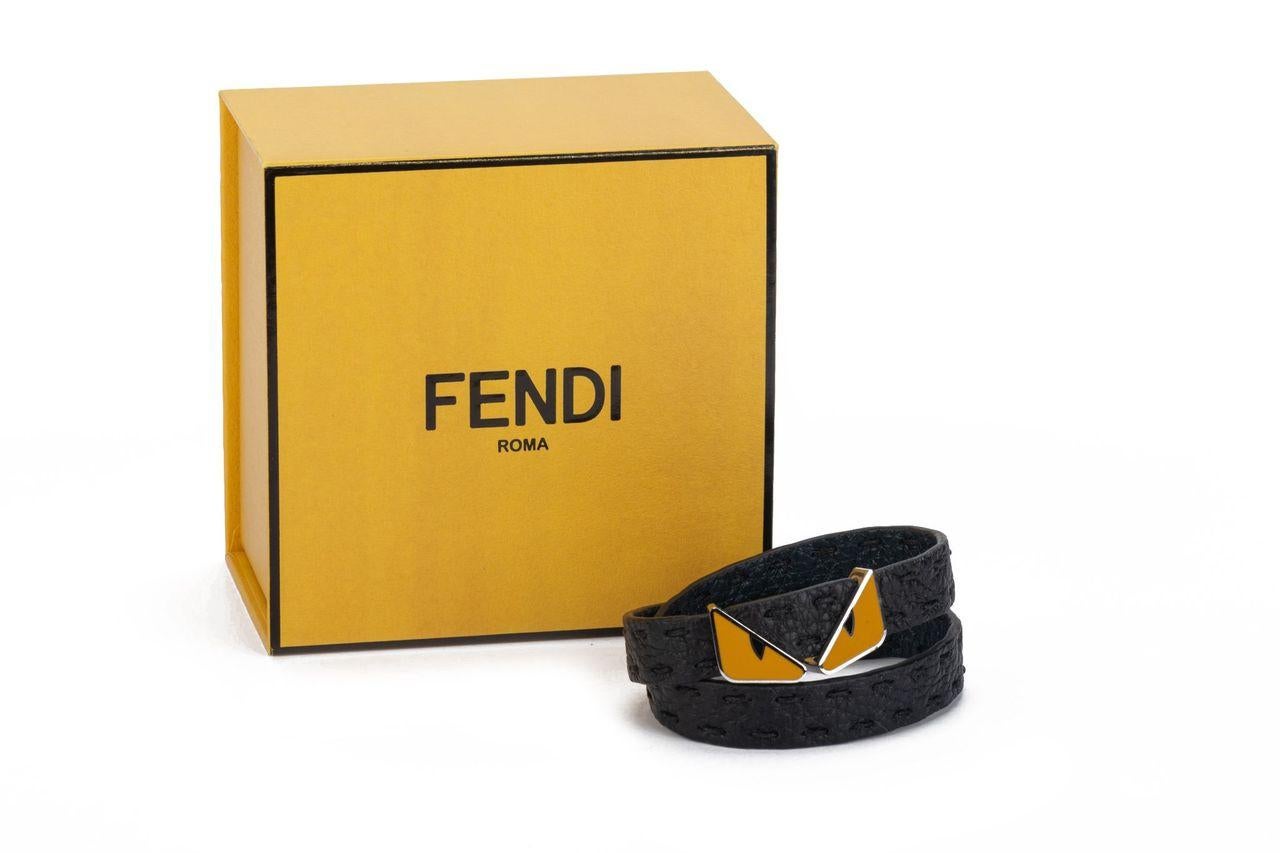 Fendi Monster double bracelet in black. The item is crafted of leather and features two Monster eyes in yellow in the middle as well as two silver buttons to close the bracelet. It is new and comes with a box and tag.
