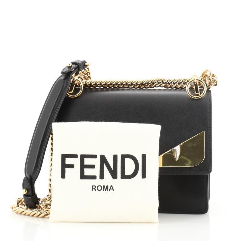 This Fendi Monster Kan I Bag Leather Small, crafted from black leather, features chain link strap with leather pad, monster eye applique design, and gold-tone hardware. Its twist-lock closure opens to a neutral microfiber interior divided into two