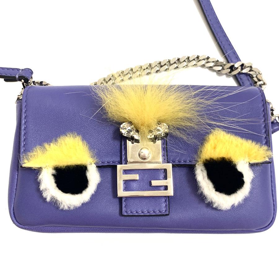 Fendi 'Monster' mini collection handbag in smooth purple leather. Silver jewelery. The mini bag is embellished with yellow tinted fur, a pearly pearl and 2 crystals. Snap closure. The interior is gray and consists of 2 bellows and 2 card slots