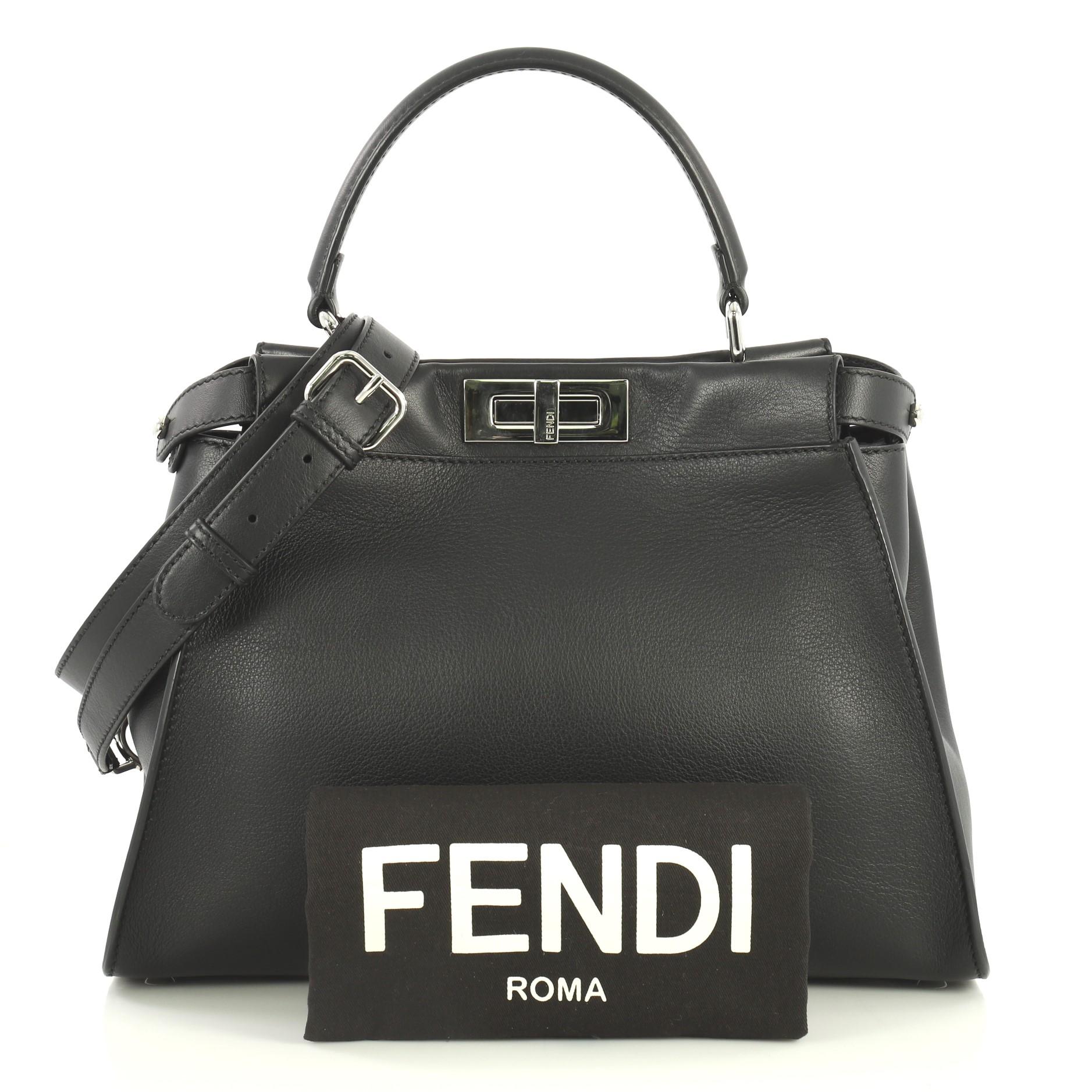 This Fendi Monster Peekaboo Bag Calfskin and Python Regular, crafted from black leather, features its yellow monster eye applique design, short leather top handle, adjustable and detachable crossbody, strap, frame top, protective base studs and