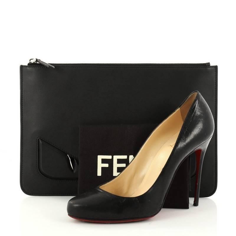 This authentic Fendi Monster Pouch Leather Medium mixes bold and chic style perfect for daily use. Crafted from black leather, this pouch features an eye-catching monster eye design and silver hardware accents. Its zip closure opens to a black
