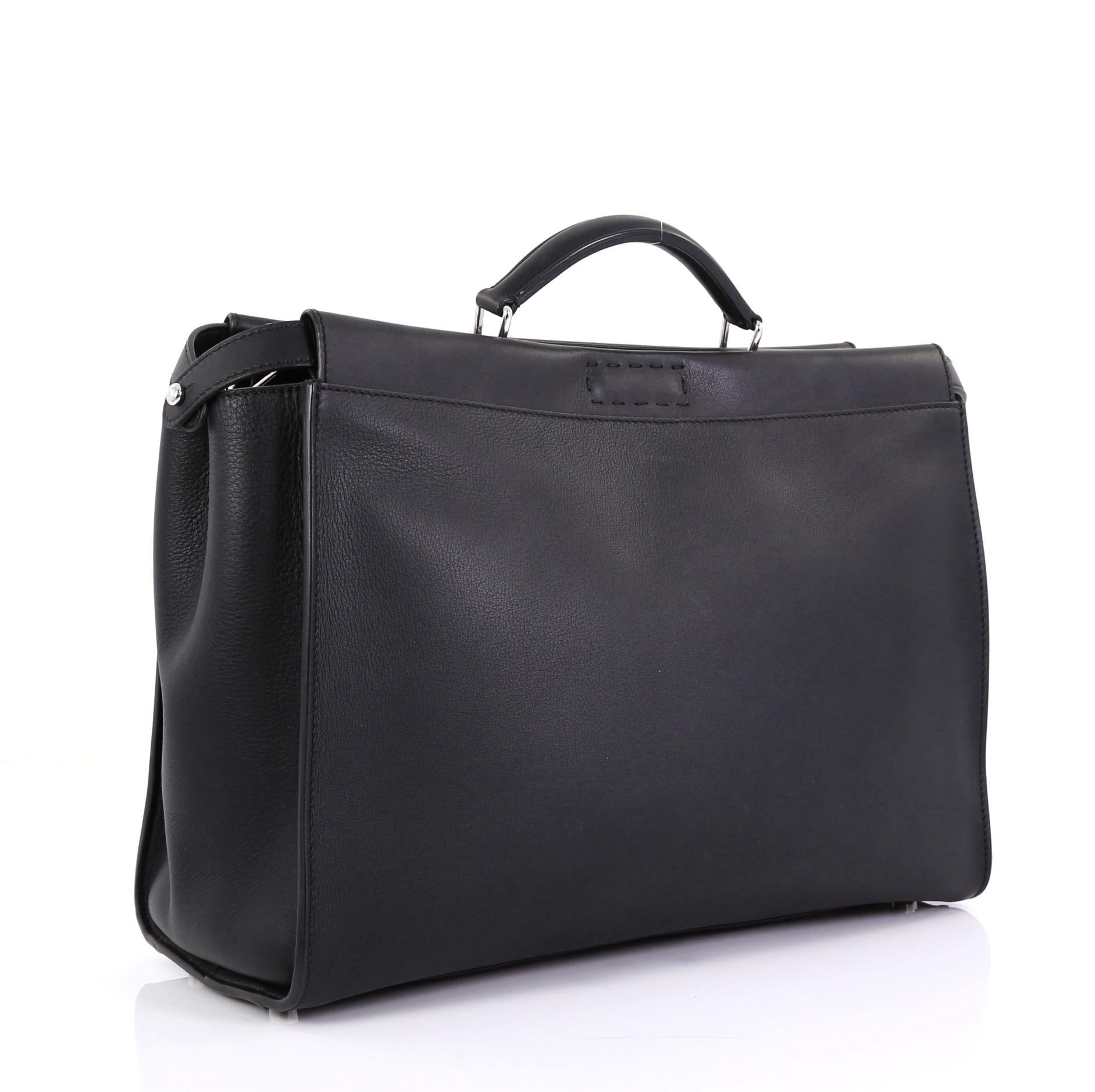 This Fendi Monster Selleria Peekaboo Bag Leather XL, crafted from black leather, features interior monster eye applique design, short leather top handle, and silver-tone hardware. Its two compartments with press-lock and zip closures open to a black
