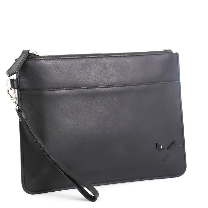 This Fendi Monster Slim Pouch Leather Small, crafted from black leather, features leather wrist strap and silver-tone hardware. Its zip closure opens to a black fabric interior. 

Estimated Retail Price: $770
Condition: Excellent. Faint scuffs on