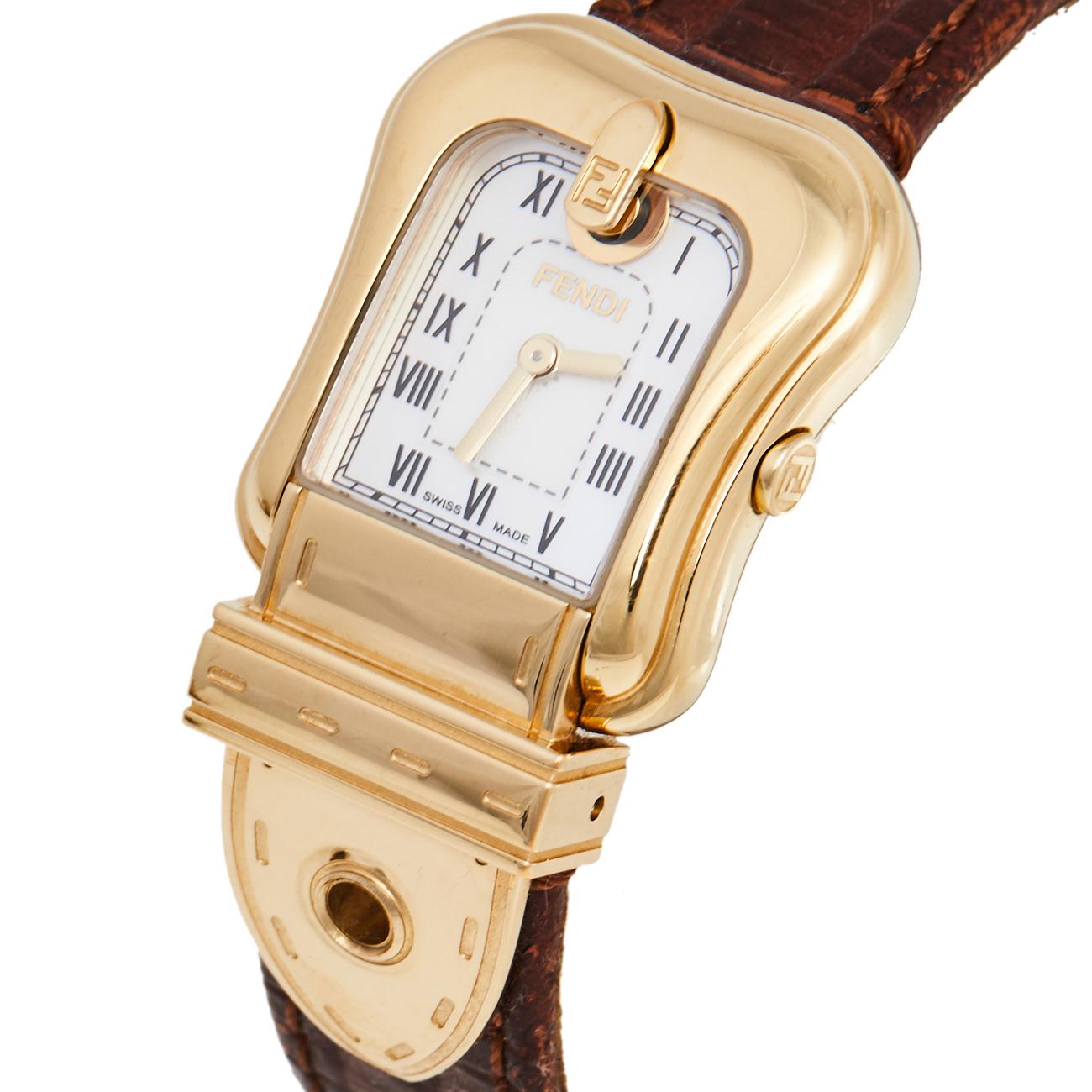 Swiss-made and created from gold-plated stainless steel, this Fendi watch flaunts a buckle-like case with Selleria stitch detailing. It has a Mother of Pearl dial set with Roman numeral hour markers and two hands, a smooth bezel, and an elegant