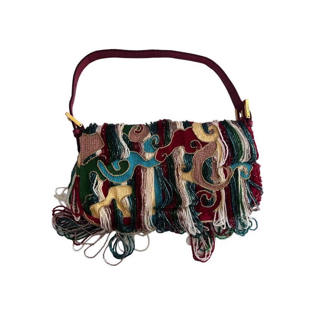 Introducing the Fendi Multicolor Beaded Wave Print Fringe Baguette, a truly unique and highly coveted piece. Featuring a stunning wave print and intricate beading, this baguette bag is a must-have for any fashion enthusiast. Its rarity makes it a