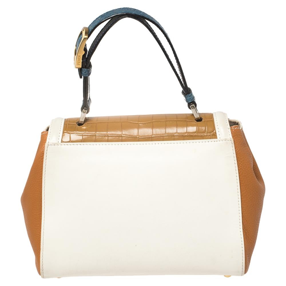 This Silvana bag by Fendi has a sophisticated look. Crafted from leather and crocodile, the bag is held by a top handle and a shoulder strap. The bag comes with protective metal feet and a flap that opens to a spacious interior. Team this fabulous