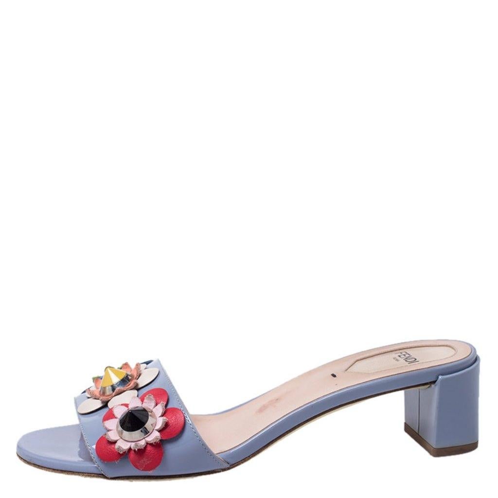 Exquisite and comfortable, these Flowerland slides from Fendi are worth every penny you spend! The slides are crafted from patent leather and feature an open toe silhouette. They are embellished with flower motifs on the front strap and set on block