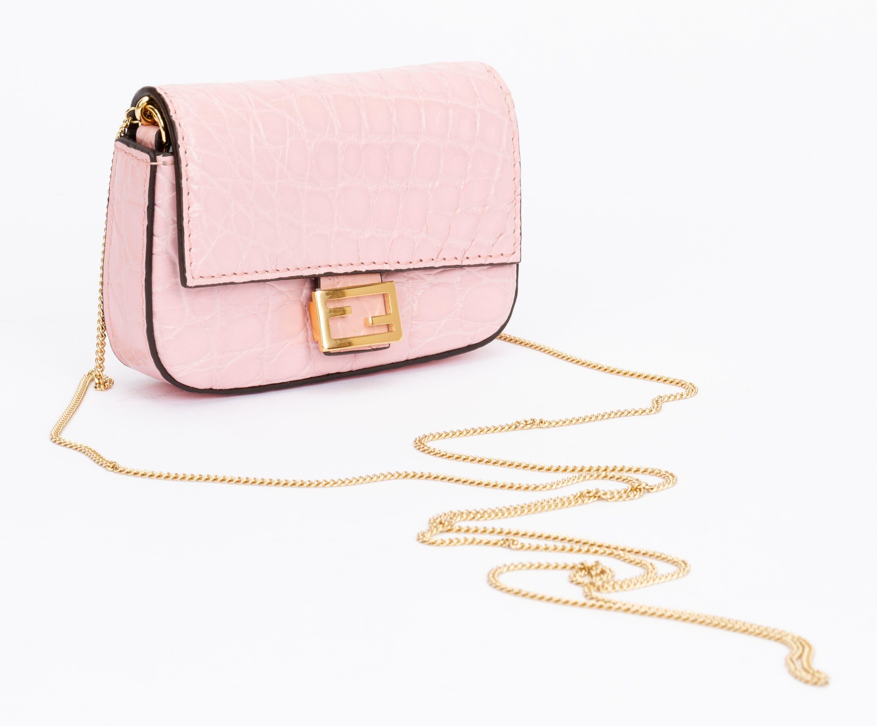 Fendi nano baguette charm made of lamb leather in pink. The pattern of the leather is crocodile skin. The charm can be attached to a bigger bag with the clip or just be worn by itself with the detachable shoulder strap (drop 23.75
