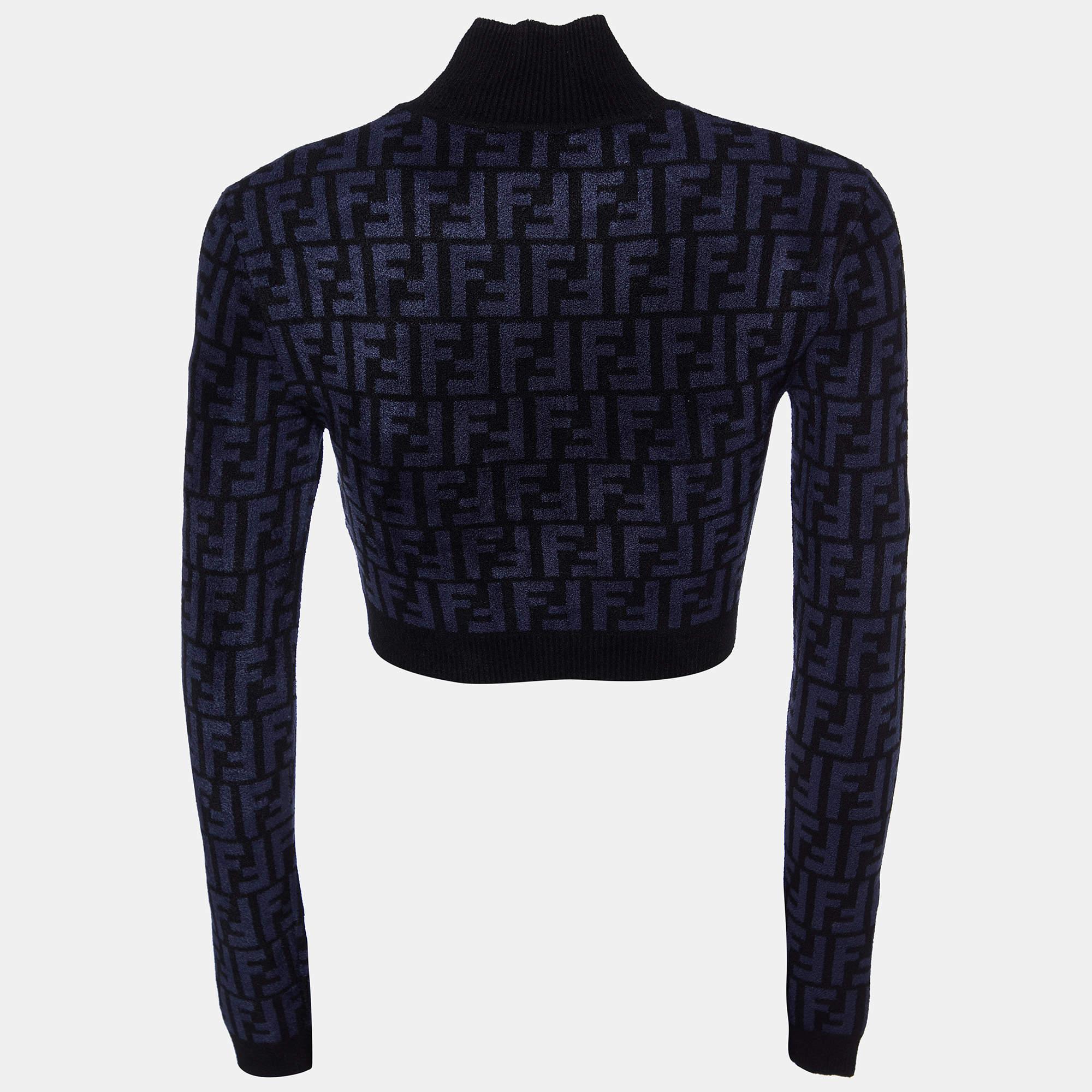 Crafted with finesse, the Fendi crop top embodies understated elegance. Its luxurious knit fabric boasts Fendi's iconic monogram in a sophisticated navy blue and black palette. The cropped silhouette exudes contemporary chic, while the crew neckline