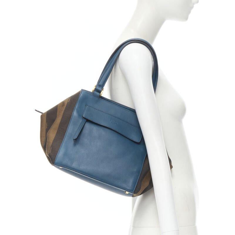 FENDI navy blue leather Penguine stripe canvas flared side tote bag
Reference: CELG/A00031
Brand: Fendi
Model: Tobacco Pequin Stripe Canvas Boston
Material: Leather, Canvas
Color: Blue, Brown
Pattern: Striped
Closure: Magnet
Lining:  Fabric
Extra