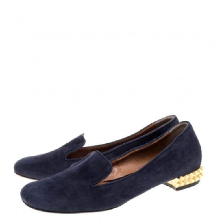 Trendy and easy to slip-on, this classy pair of Fendi smoking slippers features gold-tone studded heels. The 'Made in Italy' pair is created from navy blue suede and looks great with dresses as well as pants. Comfortable leather insoles make this