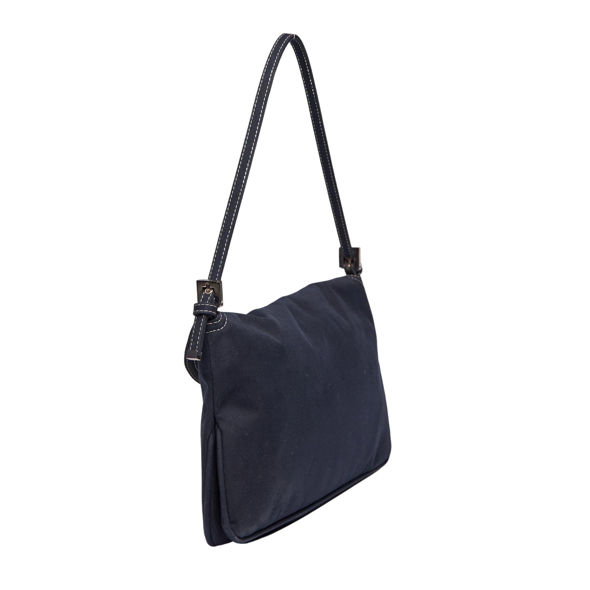 
Diese Baguette Bag von Fendi erinnert an den wieder aufkommenden Trend der 00er Jahre. Die Tasche ist aus marineblauer Baumwolle gefertigt und verfügt über eine schlanke Silhouette, silberfarbene Beschläge, weiße Kontrastnähte, einen flachen