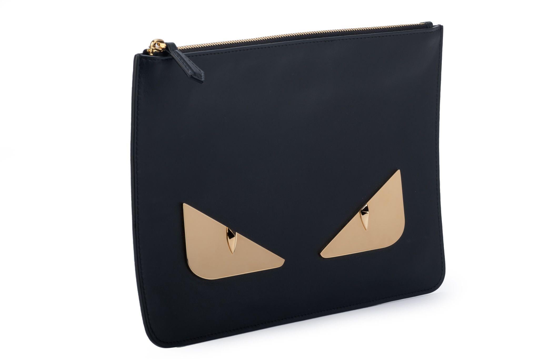 Fendi new limited edition matt finish monster black clutch with gold tone eyes. Comes with original dust cover.
