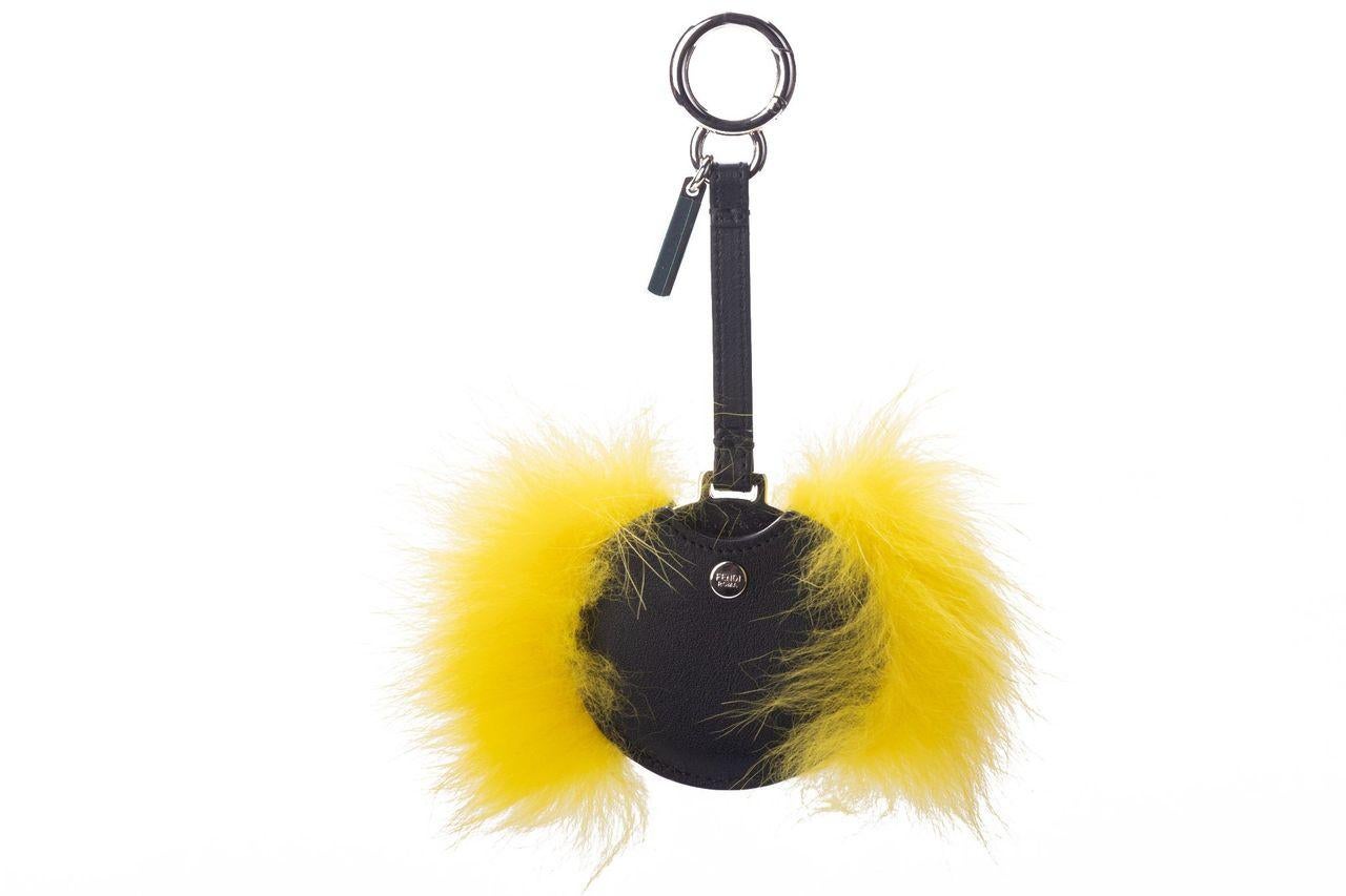 Fendi Monster key ring made of leather. Around the center piece is yellow fur and in it is a small mirror. It is new and comes with the dustbag and booklet.