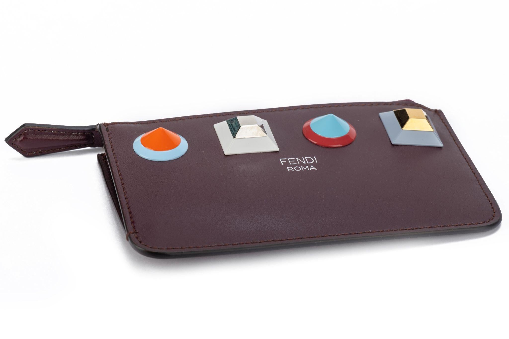Fendi nouveau porte-clés/portefeuille zippé en cuir bordeaux avec clous colorés .
Boîte et housse originale.
