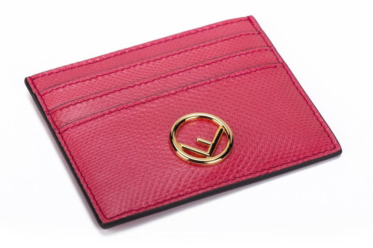 Fendi card holder in pink crafted of leather. On front of it is a golden F and it has three card departments. The piece is brand new and comes with the box and dustcover.