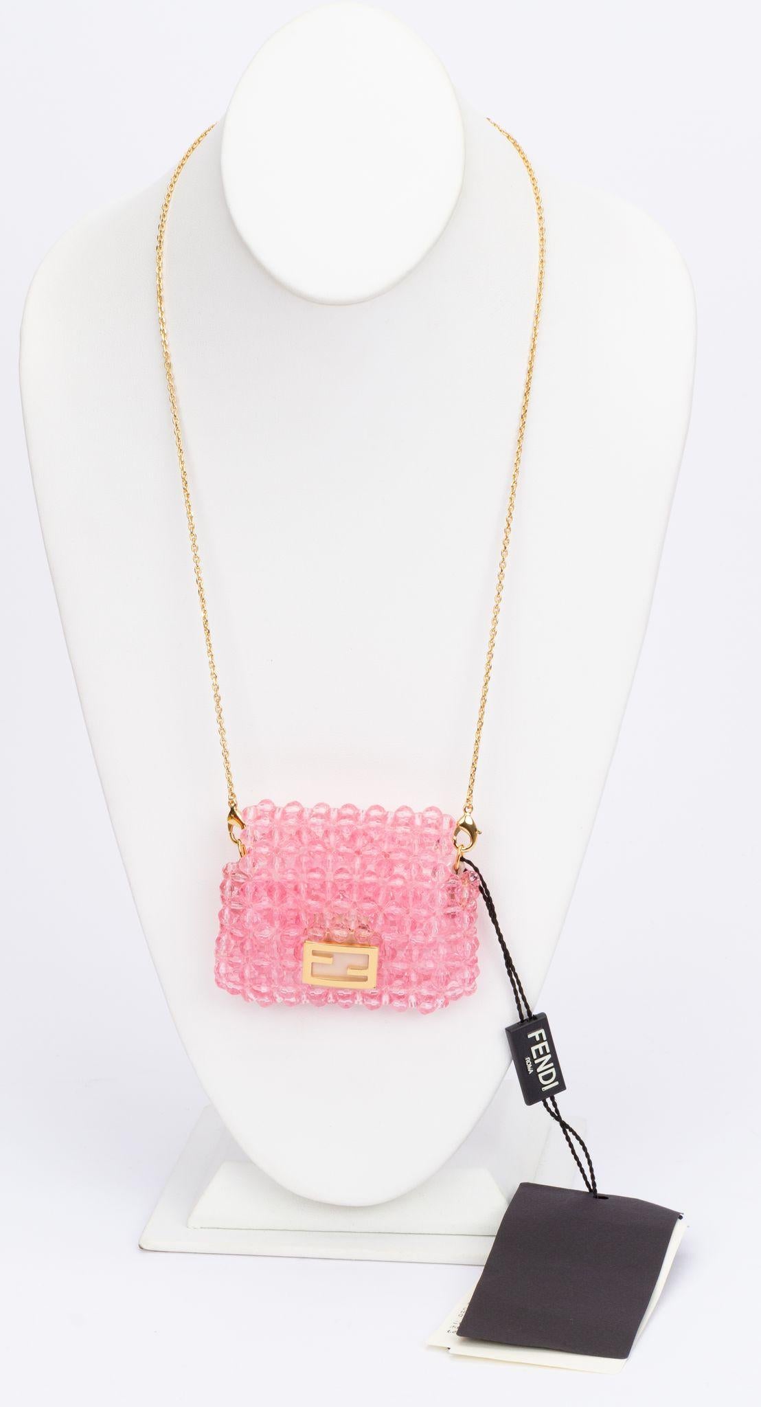 Fendi micro beaded baguette in pink. It can be attached to a larger bag or be worn at the wrist, waist as well as a necklace. It comes with an adjustable and detachable chain (drop up to 21