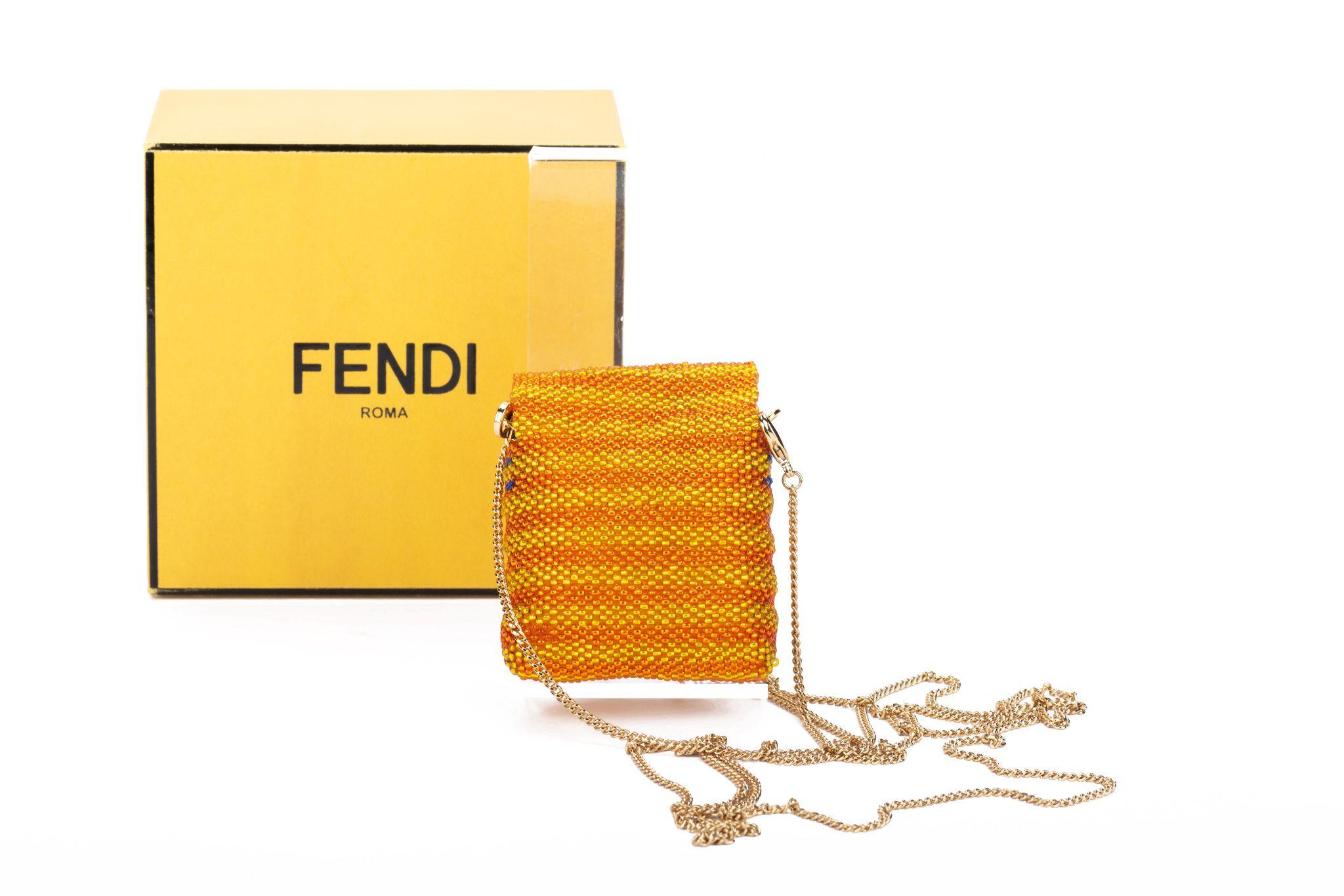Fendi NIB pico baguette in orange and yellow glass beads with a purple five-petal flower and a 23,5 inch detachable shoulder strap. Comes with box and original dust cover.
