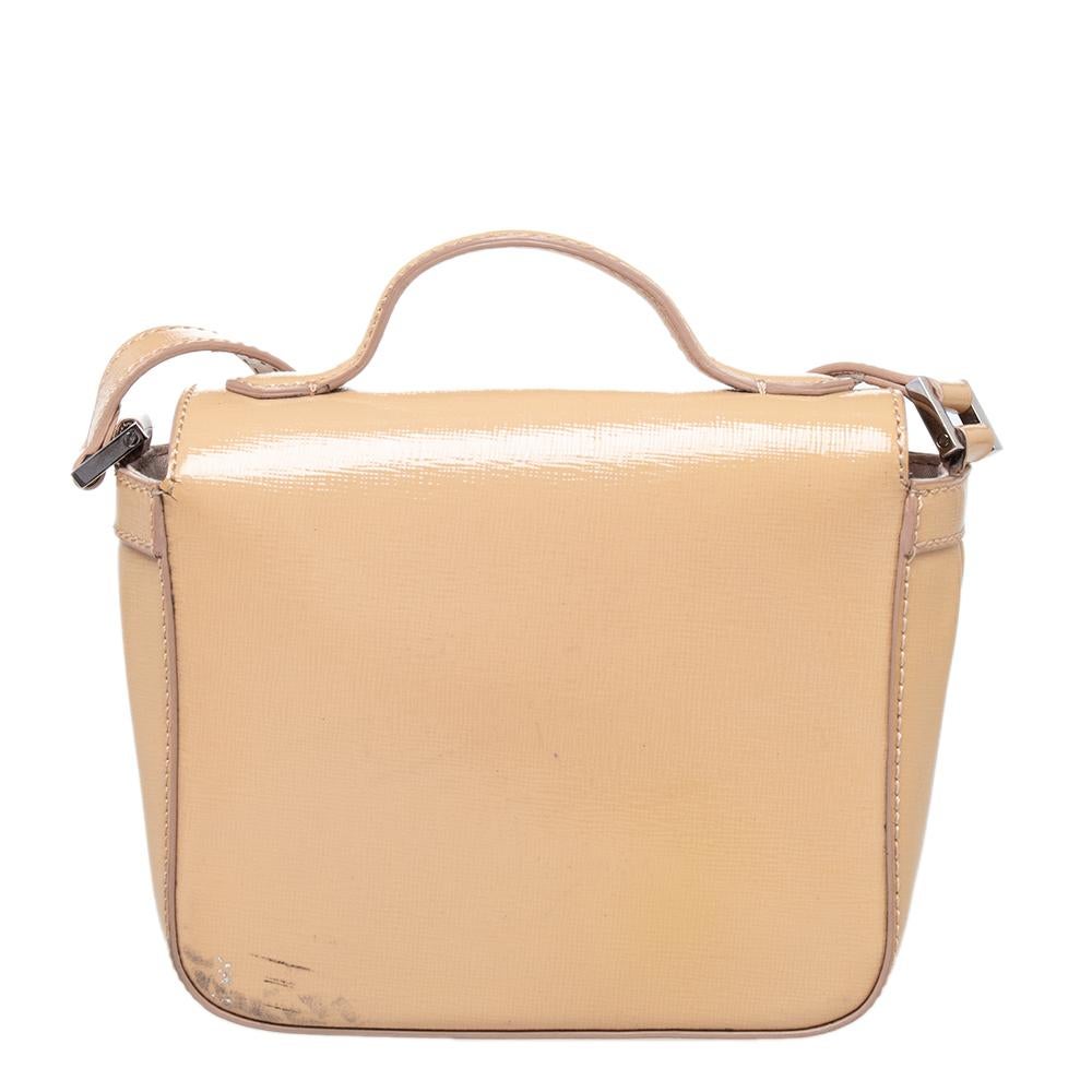 Chic and classy, this Fendi patent leather mini cross-body bag will surely be your new go-to bag. It features a shiny nude leather exterior on its structured shape and an adjustable shoulder strap. It also has a top handle and a silver-tone