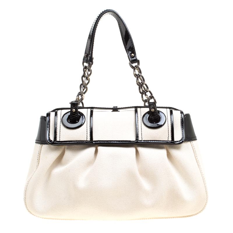 Fall in love instantly with this gorgeous B bag by Fendi. Made from canvas and styled with patent leather, this piece will smoothly last you season after season. It has two chain-leather handles, large buckle details on the front flap, and a