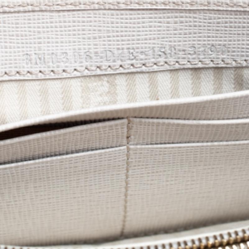 Mit dem Continental Portemonnaie von Fendi haben Sie Ihre wichtigsten Utensilien immer dabei. Das aus Leder gefertigte, cremefarbene Portemonnaie hat eine schwarze Umschlagklappe, die mit goldfarbenem Metall und dem Markennamen versehen ist.