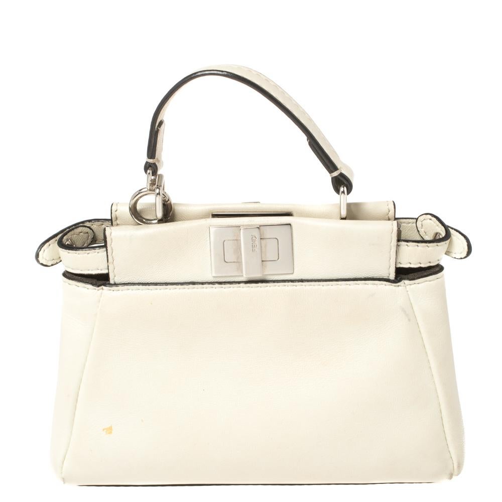 This exquisite Peekaboo from Fendi is highly coveted, and since its birth in 2009, it has swayed us with its shape, design, and beauty. This version comes meticulously crafted from off-white leather and designed with a top handle for you to swing