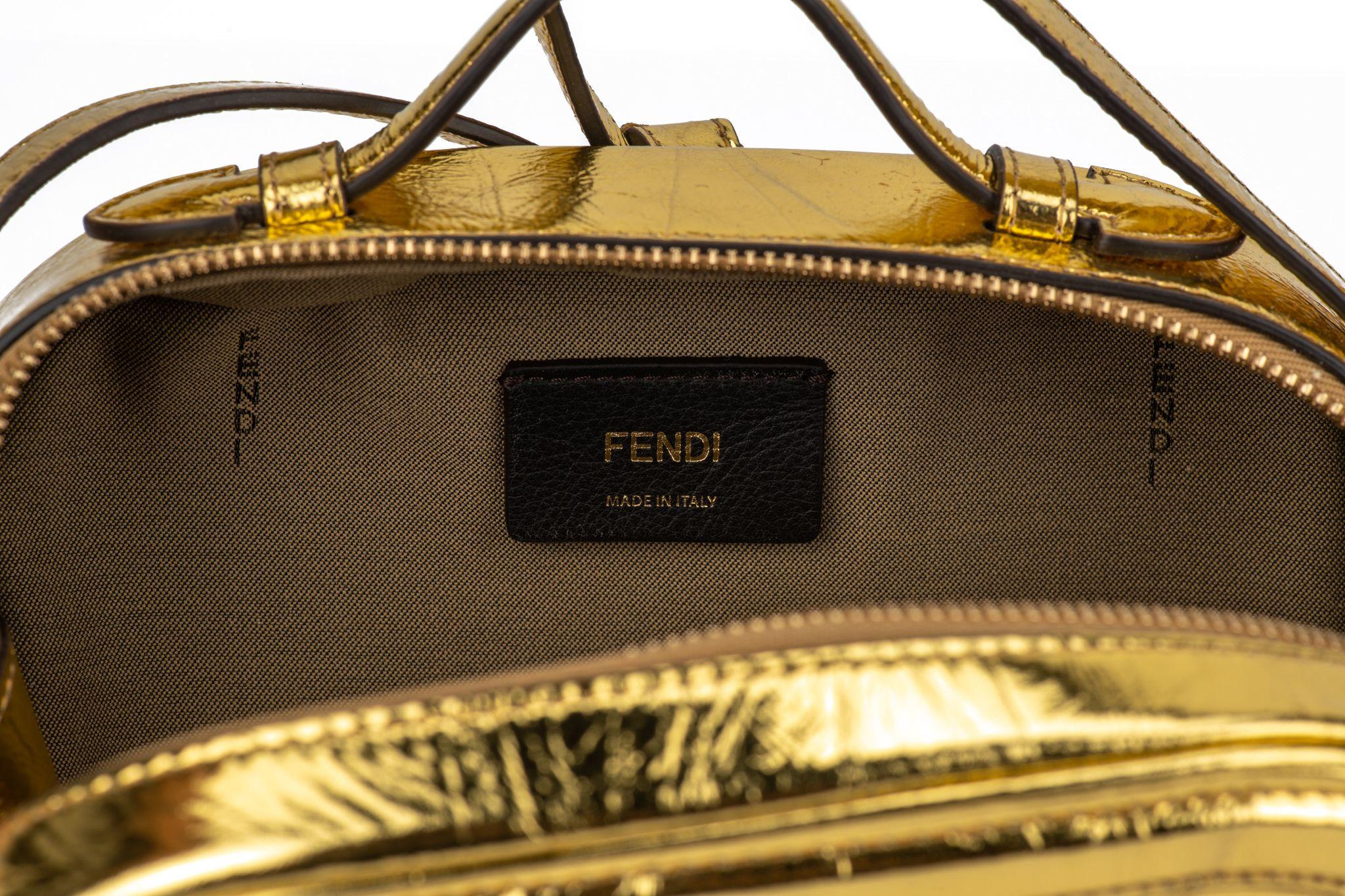 Fendi oval mini bag in gold laminated leather. Zip fastening with double slider. Outer back pocket. Featuring a lined internal compartment and gold-finish metalware. Handle drop 1.5”, detachable strap 18.5”. The bag is new and comes with the