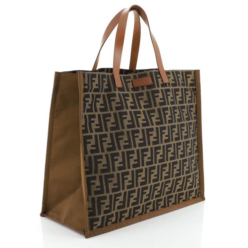 This Fendi Open Shopping Tote Zucca Canvas Large, crafted from brown zucca canvas, features dual flat leather handles. It opens to a yellow PVC interior. 

Condition: Damaged. Heavy separating on interior side lining. Large watermark on base,