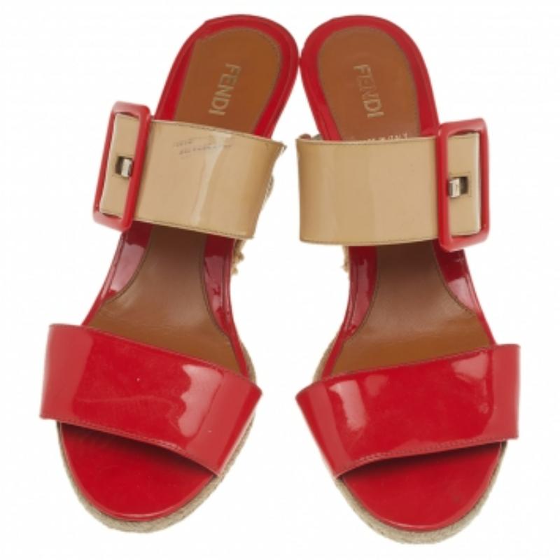 Starten Sie in den Sommer, indem Sie schicke, auffällige Modelle wie diese Sandalen tragen. Diese Sandalen von Fendi sind aus orange-beigem Lackleder gefertigt und mit goldfarbenen Elementen und Keilabsätzen versehen. Vervollständigen Sie Ihr