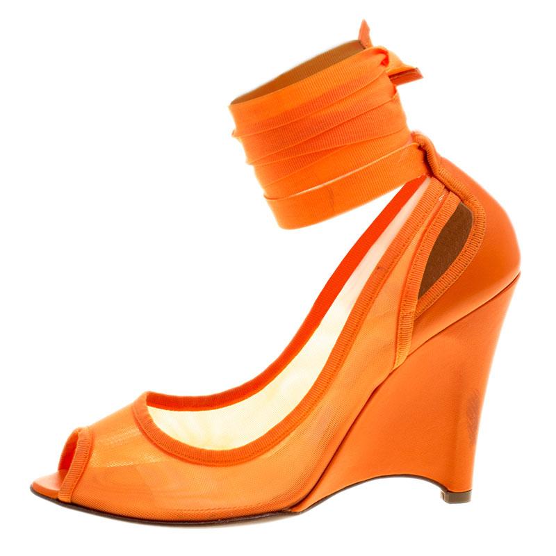 Get into the season's latest trends with these stunning Fendi pumps. Fashioned in a vibrant orange hue, this piece is crafted from a mesh and leather artfully combined and set on towering wedge heel. It comes with an ankle wrap that stands as a