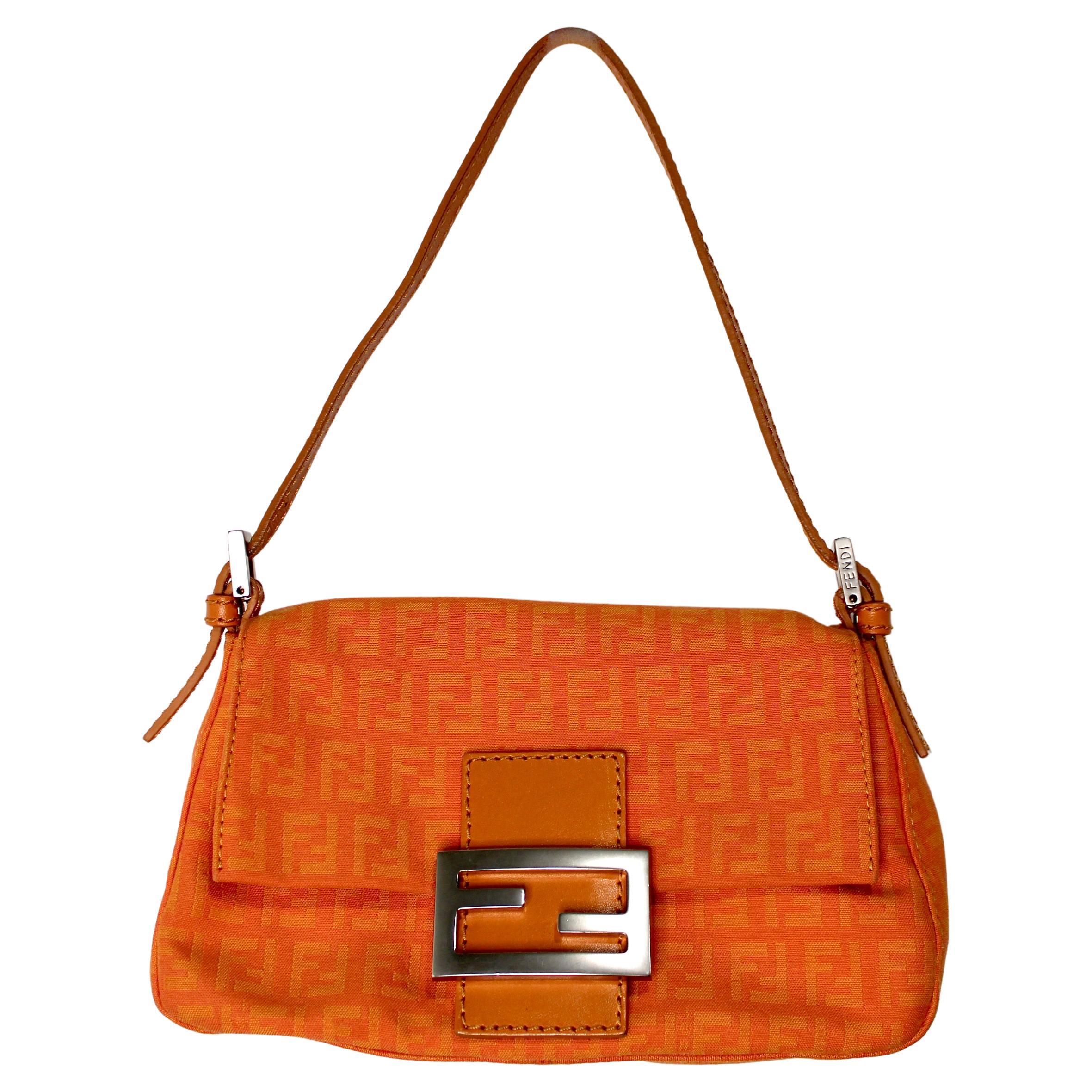 La borsa Fendi Orange Mini Mama Zucchino Baguette dell'anno 2000 è un accessorio quintessenziale che cattura lo spirito giocoso e lussuoso della moda dei primi anni 2000. Realizzata con l'iconica tela Zucchino di Fendi in una vibrante tonalità