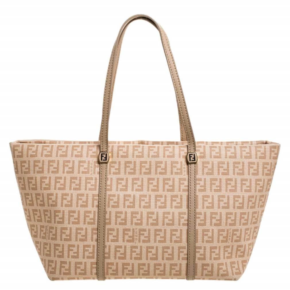 This Licious tote by Fendi is a closet must-have. Crafted in Italy, this bag is made of the brand's signature Zucchino coated canvas and comes in a stunning shade of peach. It exudes style, comfort and femininity. It comes with dual handles, top-zip