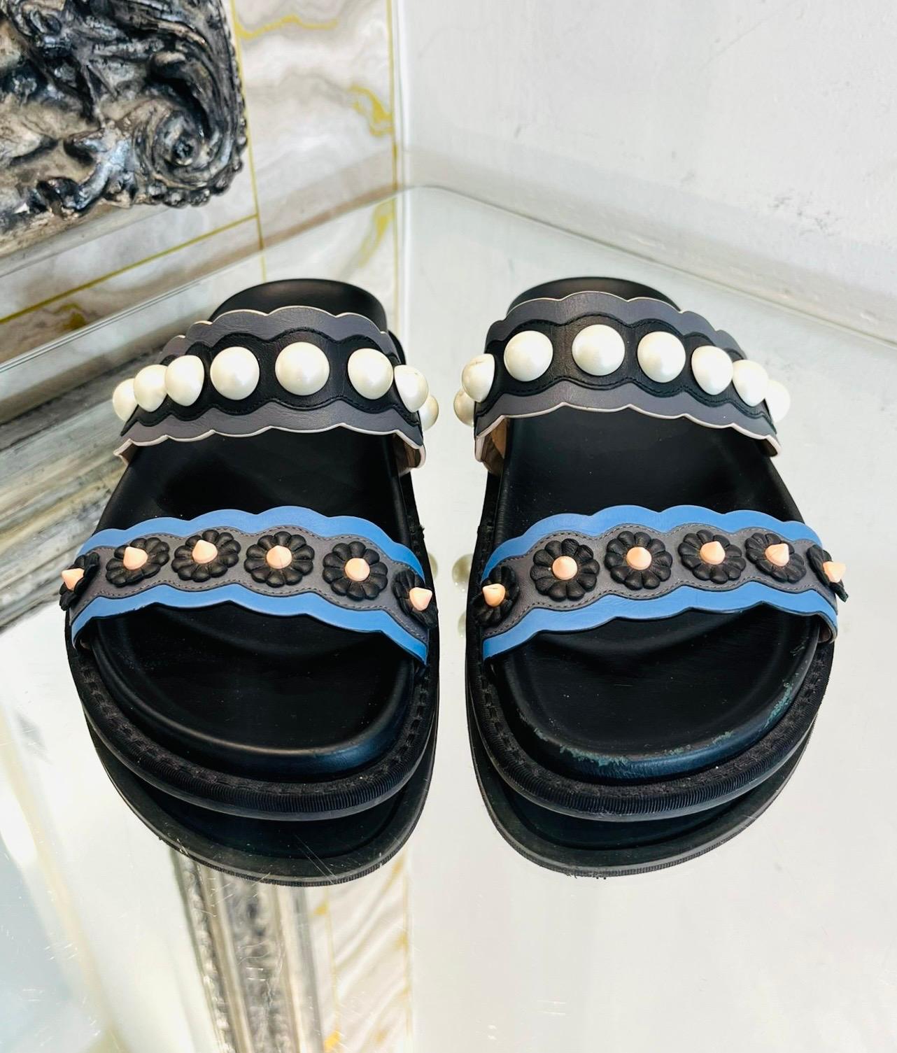 Fendi Pearl Embellished Leather Slides

Black slides designed with wide dual strap in blue and grey, detailed with white faux pearls and flowers motifs.

Featuring sturdy outsoles and open toes. 

Size – 36

Condition – Fair/Good (Signs of wear to