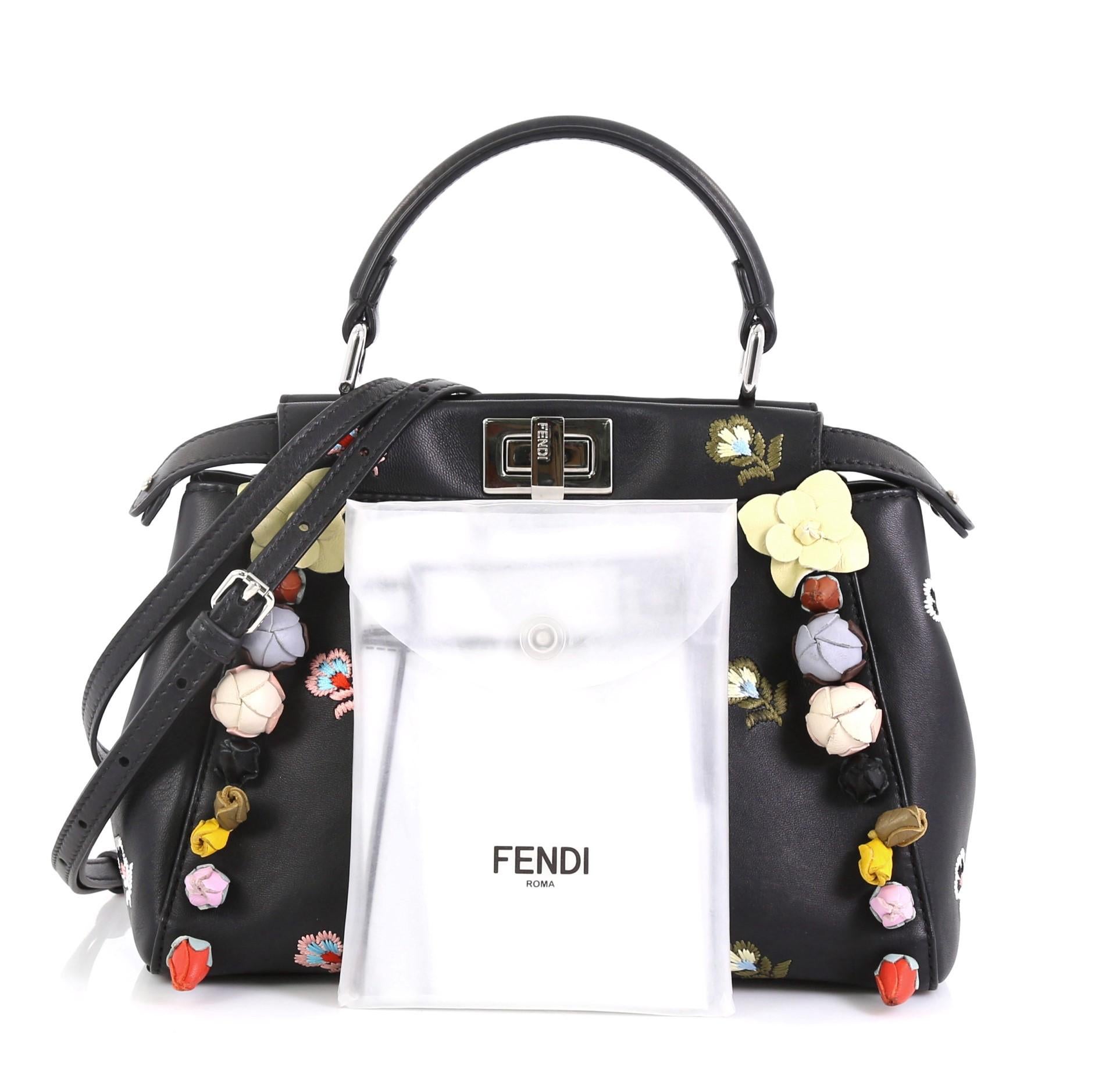 This Fendi Peekaboo Bag Embroidered Leather with Floral Applique Mini, crafted in black leather, features leather top handle, embroidered floral prints with floral applique, bar frame and silver-tone hardware. Its turn-lock closure opens to a black