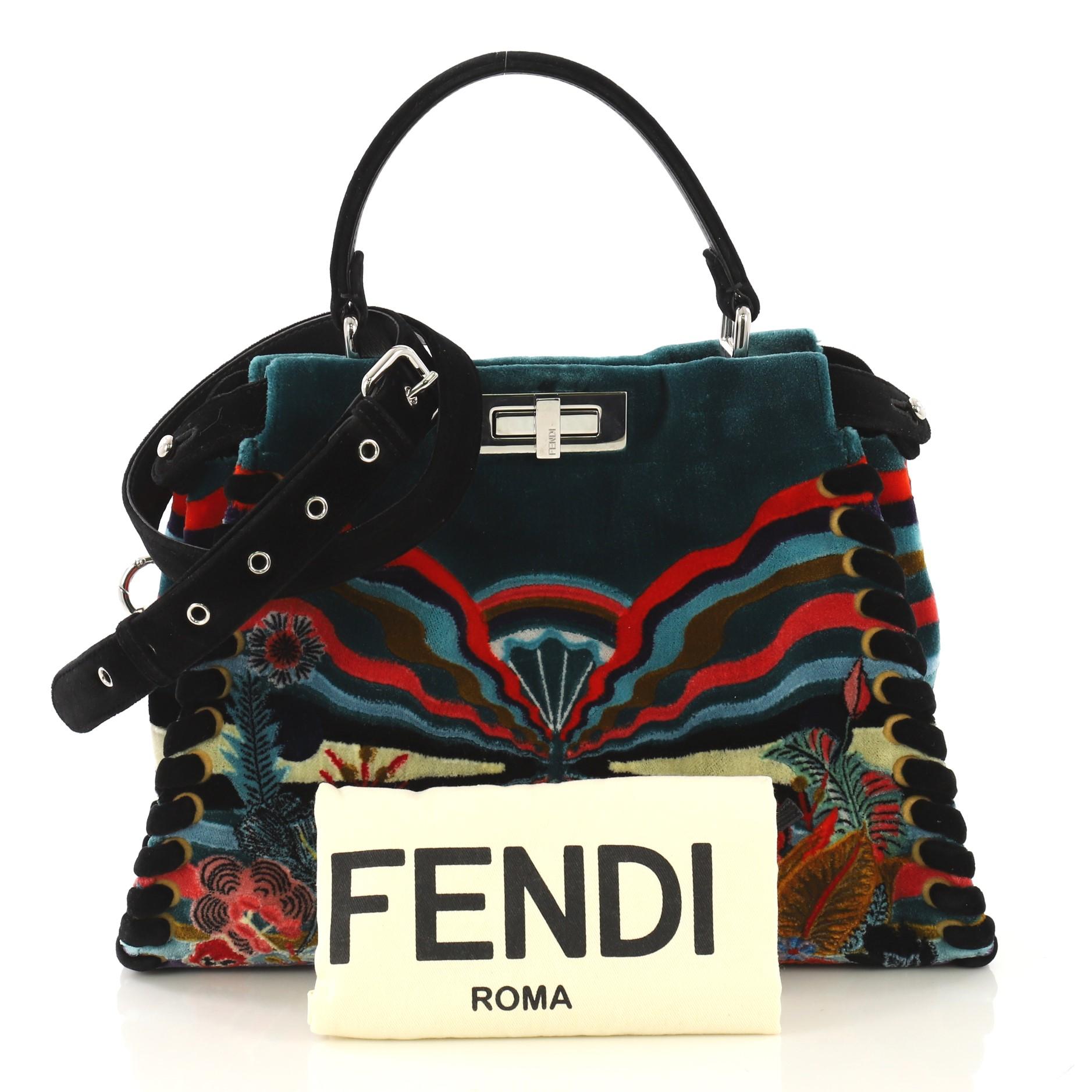 This Fendi Peekaboo Bag Embroidered Velvet Medium, crafted from green embroidered velvet, features a top frame silhouette, flat top handle, protective base studs, and silver-tone hardware. Its turn-lock and magnetic snap closures open to a black